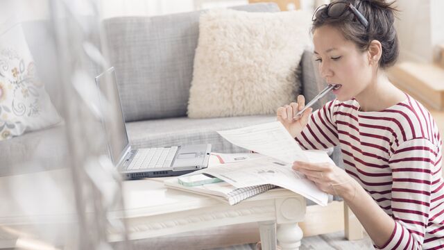 Ung kvinne sosm betaler regninger på lap top